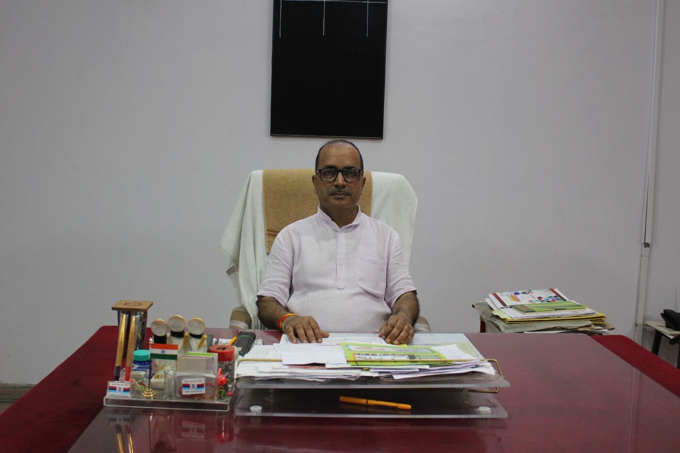 Principal of SVM Inter College seated at his desk in the office