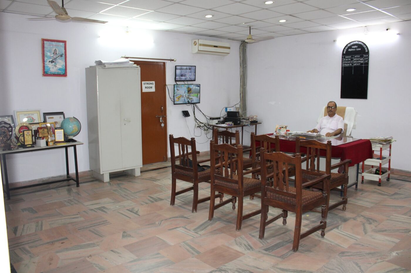 Administrative room with wooden chairs, storage cupboard and a working desk