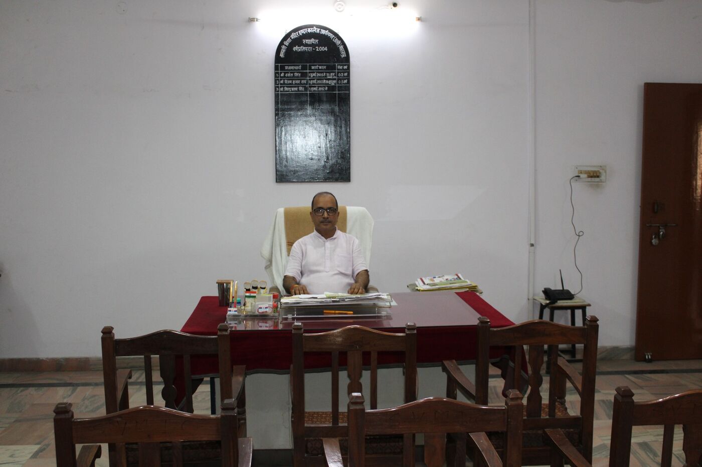 Member of staff working at a wooden desk in the college office