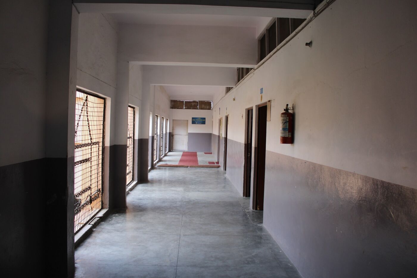 Long corridor with a grille window and classroom entrances