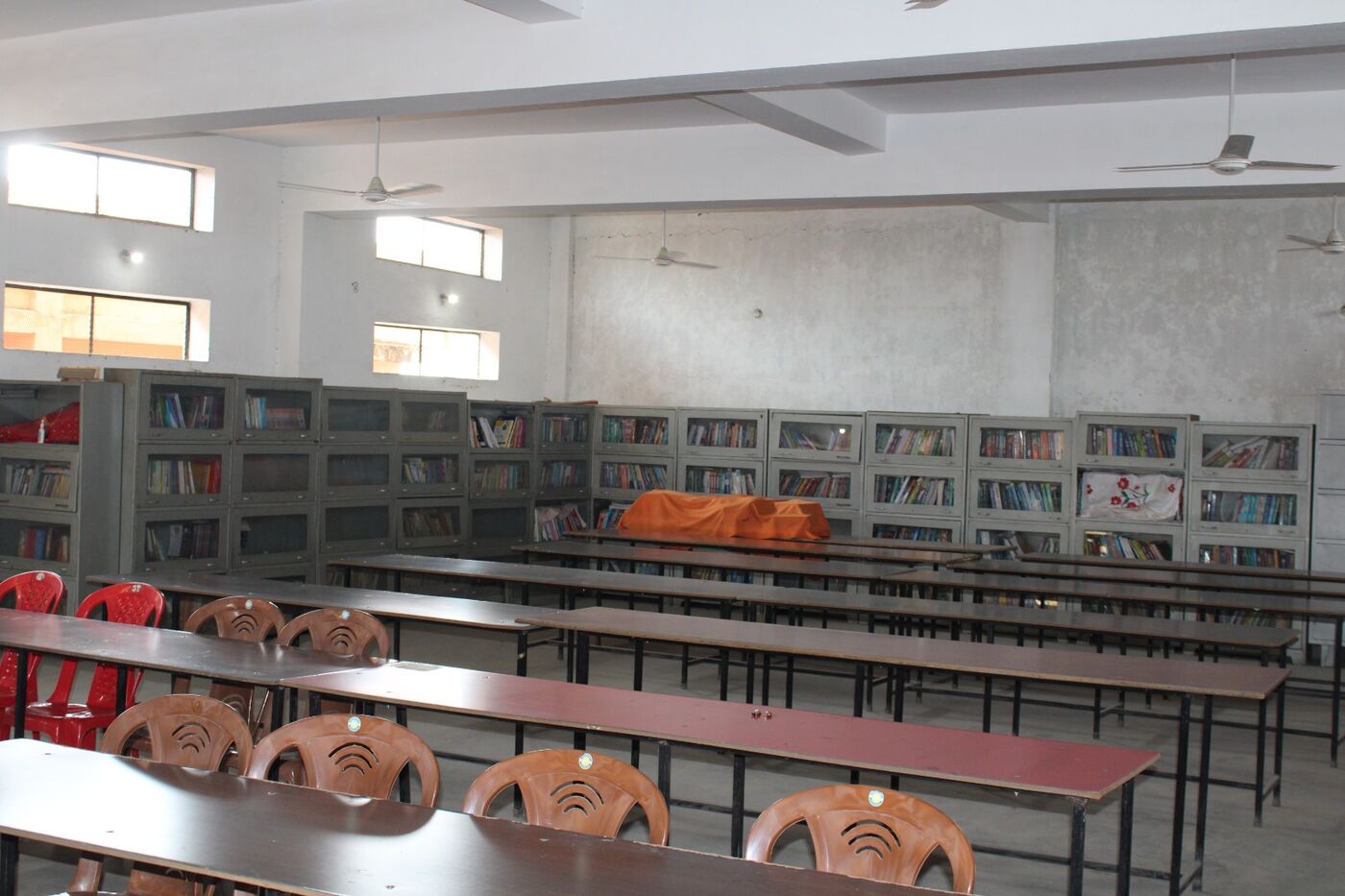College library with wall-to-wall book racks and long reading tables