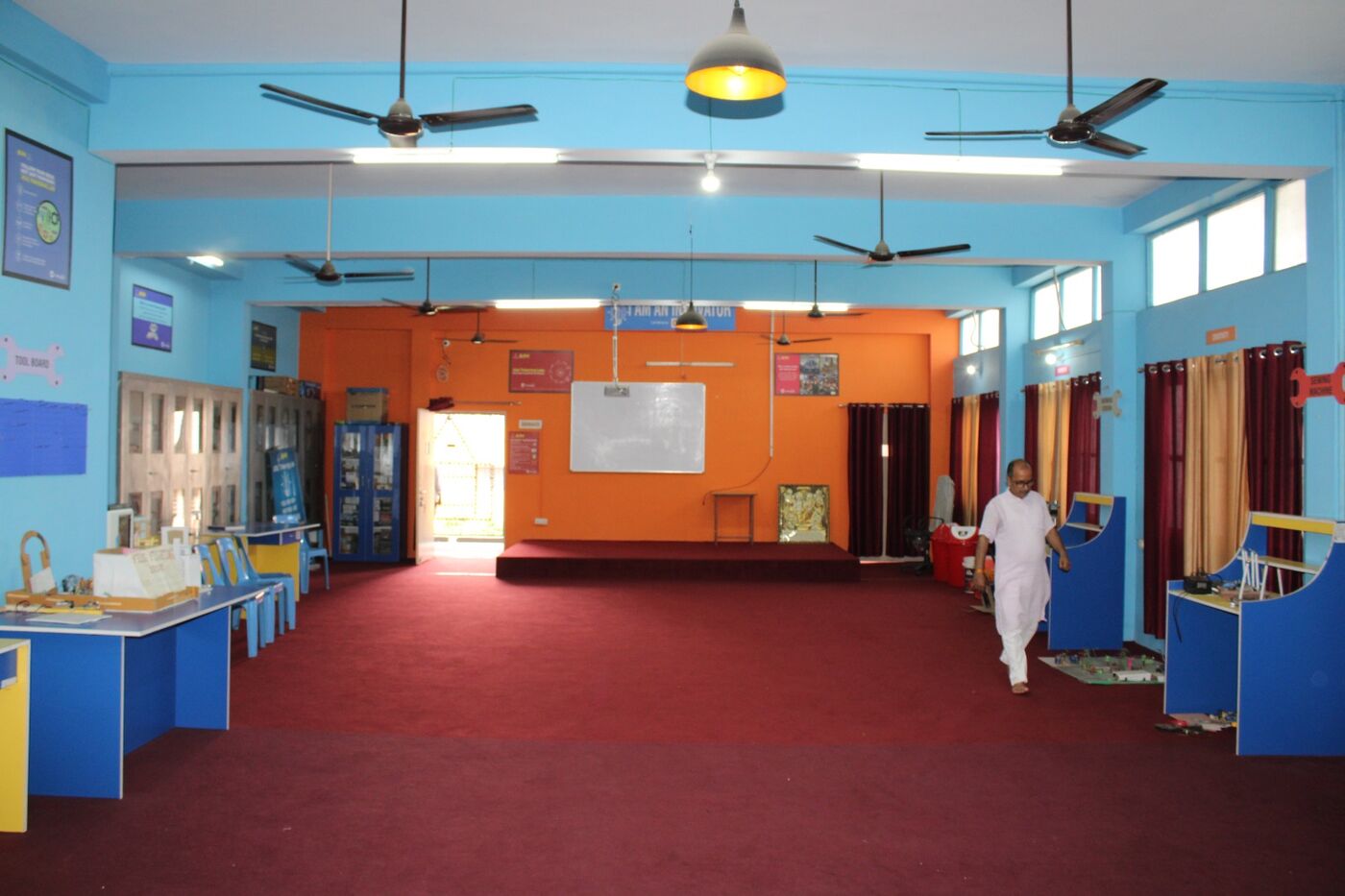 Junior activity laboratory in orange and blue with display boards and work stations