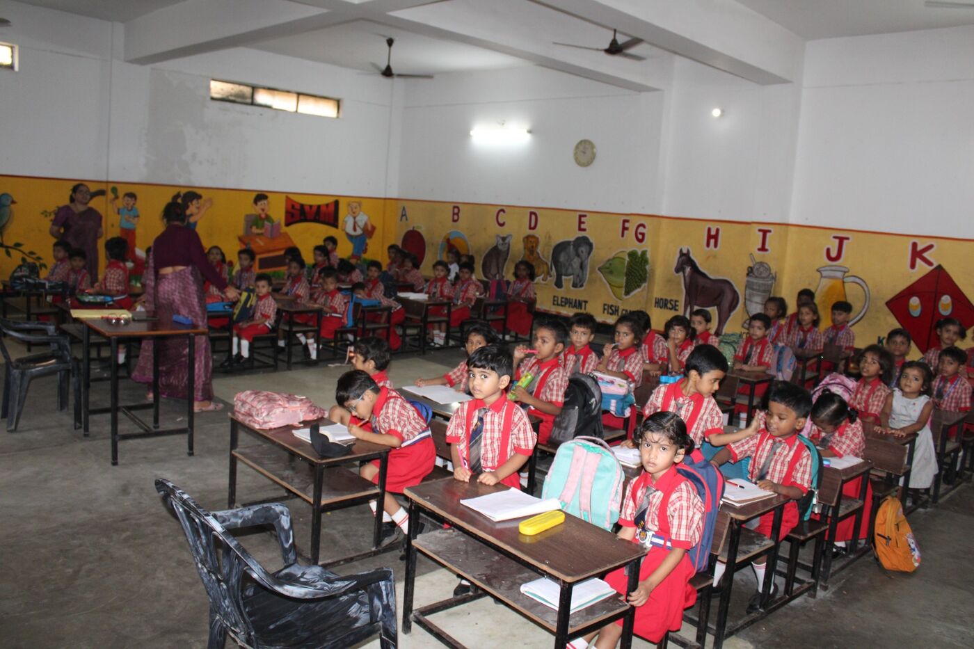 Primary section classroom with young children and colourful learning charts on the walls