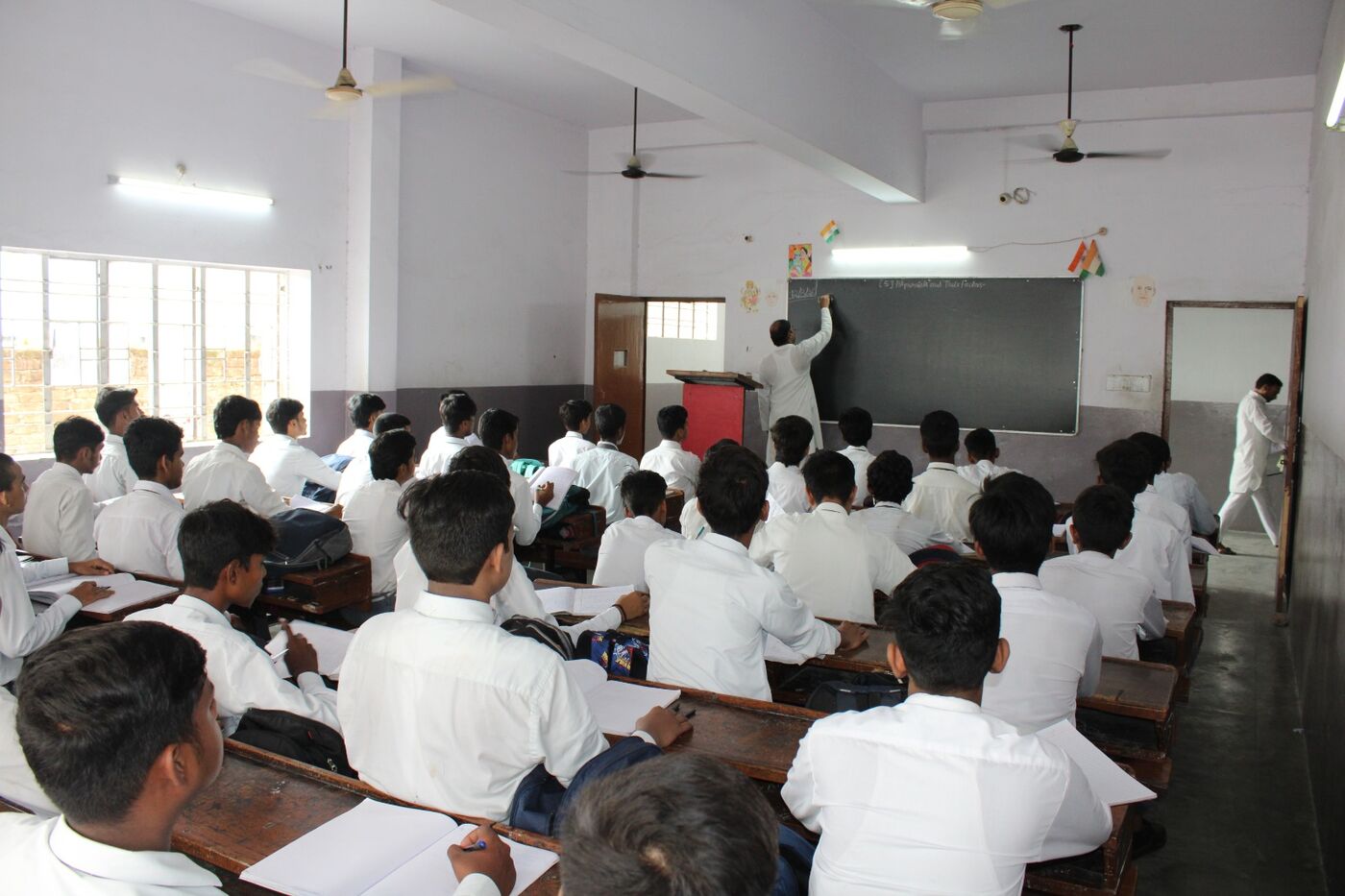 Class in progress with students facing the blackboard